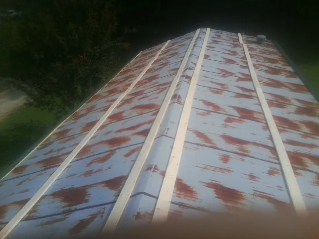 Rusted metal roof panels with new wood purlins before replacement — Storm Damage Roof Repair in Kemp by Roofing Brothers