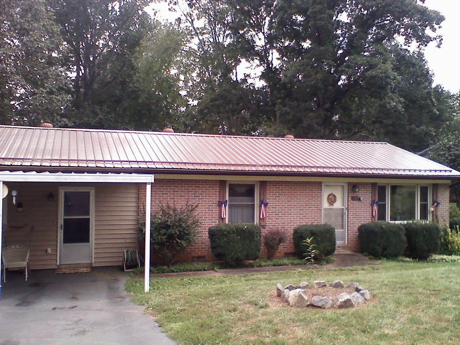 Bronze metal roof and carport on a brick ranch home — Roof Repair work by our crew in Kemp